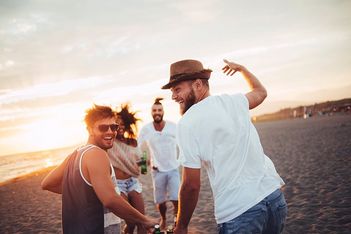 Sonnenliegen am Strand unter Palmen am türkisfarbenen Meer slide-1